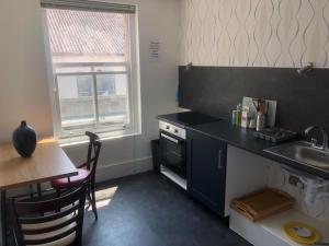 伦敦Cosy Studio Apartment - Blackheath, Greenwich的一个带水槽、桌子和柜台的小厨房