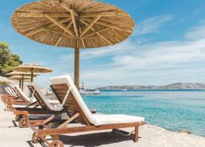 希贝尼克Obonjan Island Resort的海滩上的一组椅子和遮阳伞