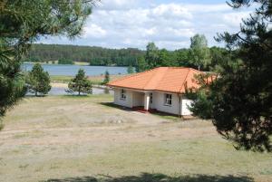 StudzieniceOśrodek wypoczynkowy Jezioro的一座白色的小房子,拥有橙色的屋顶