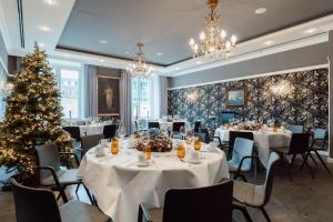 明斯特凯撒霍夫酒店的用餐室配有桌子和圣诞树