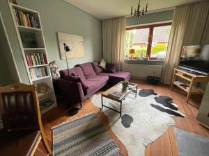 弗伦斯堡Ferienhaus Jenny的客厅配有紫色沙发和桌子