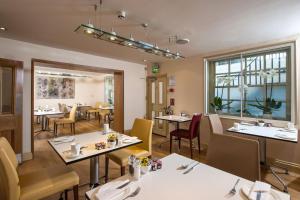 伦敦切尔西悉尼大楼酒店的一间带桌椅的餐厅和一间用餐室