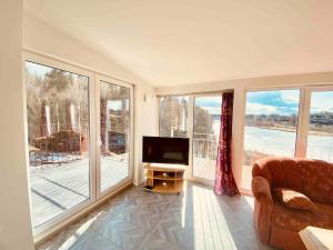 FlenBjurviks Villa - Flat 3的一间带电视和大窗户的客厅