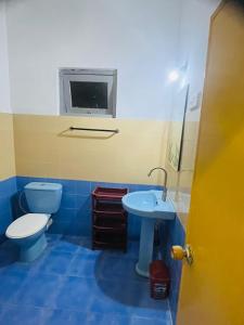 希克杜沃Susha Happy One 2BR First Floor Apartment的蓝色的浴室设有卫生间和水槽