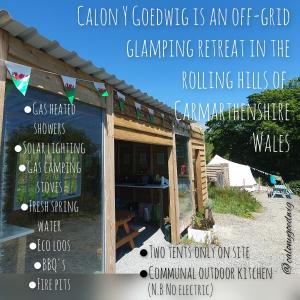 兰达弗里Calon Y Goedwig Glamping的荒野连绵起伏的丘陵露营的标志