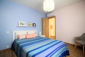 卡巴纳斯·德·塔维拉Mimosa House Cabanas的蓝色卧室,配有床和椅子