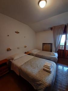 塞斯托拉Hotel Calvanella的酒店客房设有两张床和窗户。