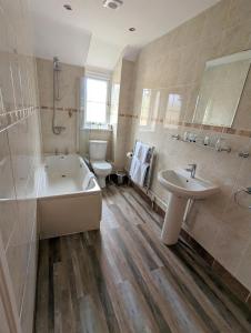阿斯克The Lodge by Cefn Tilla的带浴缸、盥洗盆和卫生间的浴室