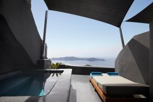 易莫洛林Kivotos Santorini的一个带游泳池和浴缸的客房