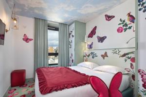 巴黎维斯维萨酒店的一间卧室配有一张带蝴蝶墙贴花的床