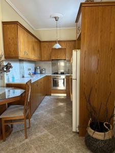 NénitaGavrilis Apartments的厨房配有木制橱柜、桌子和冰箱。