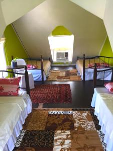 Santa RosaMadie's Place Bed & Breakfast in Santa Rosa, Laguna near Enchanted Kingdom的带四张床和窗户的客房