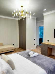阿特劳Talan life aparts的卧室配有一张白色大床和吊灯。