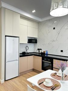阿特劳Talan life aparts的厨房配有白色冰箱和桌子
