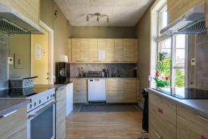 利雪平Nicolai B&B的厨房配有木制橱柜和白色冰箱。