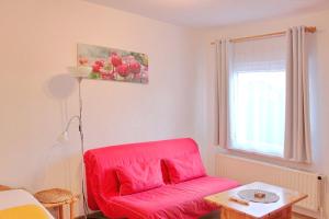 吕本瑙Pension An der Kamske, FZ 5 Familien的客厅配有红色椅子和窗户