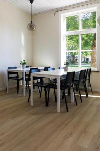 利雪平Nicolai B&B的用餐室配有白色桌子和黑色椅子