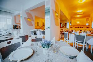 伯伊莱图什纳德Hotel Tusnad的用餐室配有白色的桌子和白色的椅子