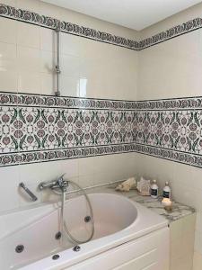 塔巴卡Villa avec piscine privée的带浴缸的浴室和瓷砖墙