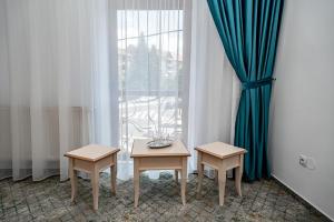 锡比乌里恩酒店的窗前的一张桌子和两把椅子