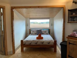 金斯林Woodpecker Cabin with Hot tub的一个小房间的一个床位,设有窗户