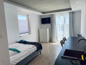 尼彻兹BLOMMA Niechorze的一间卧室配有一张床、一张书桌和一个窗户。