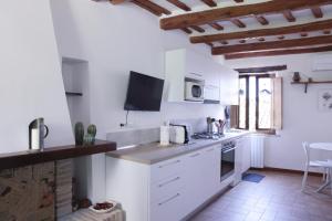 马切拉塔CIRIBACCO ROOMS的厨房配有白色橱柜和台面