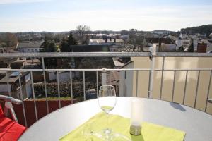 奥斯赛拜-塞林Haus Möwe II - Ferienwohnung 10的坐在阳台上的桌子上,喝一杯葡萄酒