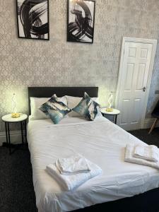 伊斯特布恩OYO Marine Parade Hotel, Eastbourne Pier的卧室配有白色的床和2条毛巾