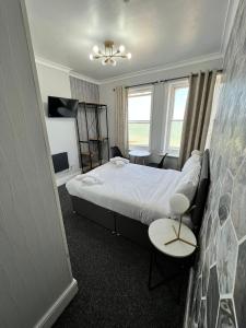 伊斯特布恩OYO Marine Parade Hotel, Eastbourne Pier的酒店客房带一张床、一张桌子和椅子