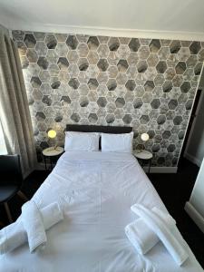 伊斯特布恩OYO Marine Parade Hotel, Eastbourne Pier的卧室配有白色的床和2条毛巾