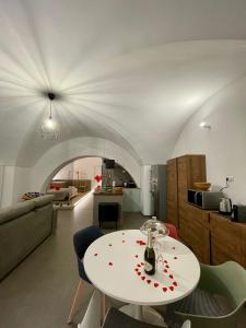 布林迪西Archome Luxury Apartment的一间带白色桌子的客厅和一间厨房