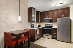斯帕坦堡Residence Inn by Marriott Spartanburg Westgate的厨房配有桌子和不锈钢冰箱。