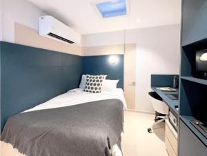 新加坡ISA Hotel Amber Road的一间卧室配有一张蓝色墙壁的床