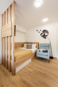 RadečeApartments Gros的一间卧室配有一张床和一张蓝色椅子