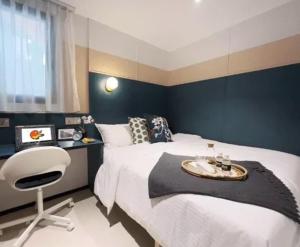 新加坡ISA Hotel Amber Road的一间卧室配有一张大床和一把椅子