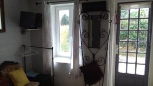 Saint-Germierwhite house的一间设有门、电视和窗户的房间