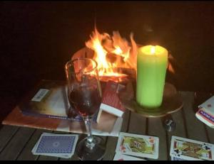 Gheerulla奥基溪私人休闲公寓的桌上放着蜡烛和葡萄酒杯,放着火