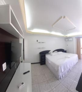 马瑙斯Riverfront Retreat Prime Location Apartment with Stunning Views of the RioNegro的一间卧室配有一张床和一台平面电视