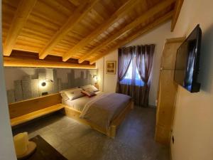 平佐洛B&B Casa il sasso的一间卧室配有一张大床和电视