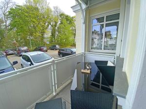 奥斯特巴德·哥伦Villa Strandmuschel - FeWo 01的停车场内可停放汽车的阳台