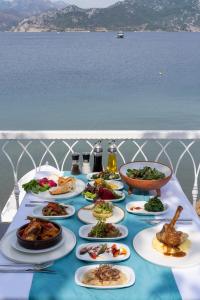 马尔马里斯BÜŞRA SELİMİYE的桌子上放着食物的盘子,桌子上放着水