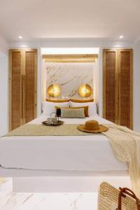 阿吉奥斯普罗科皮奥斯Venus Suite with Hot Tub的一间白色的卧室,配有一张带帽子的床