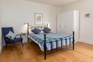 兰戈伦Cefn Ceiriog的一间卧室配有一张床、一把椅子和一个橱柜