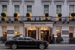 伦敦Brown's Hotel, a Rocco Forte Hotel的一辆黑色汽车停在一家棕色酒店前