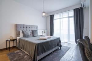 贝尔格莱德Belgrade Waterfront - River Residence的一间卧室设有一张床和一个大窗户
