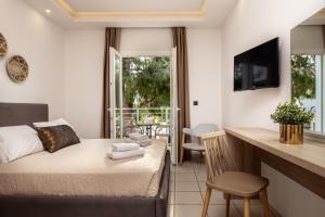 卡拉马孔Aeolos Boutique Hotel and Suites的一间卧室配有一张床,厨房设有阳台