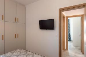 KrotiriParikia's Sunlight 2bedroom House的卧室配有白色墙壁上的平面电视。
