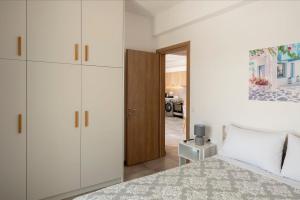 KrotiriParikia's Sunlight 2bedroom House的一间卧室配有一张床和白色橱柜,还设有一间厨房
