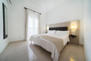 阿德耶LABRANDA Bahía Fañabé & Villas的卧室设有一张白色大床和一扇窗户。